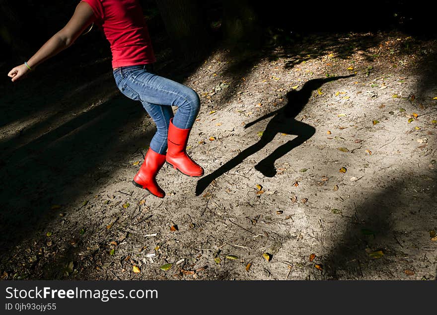 Photography of a Girl in Red Shirt With Blue Denim Jeans and Red Leather Wide-calf Boots Jumping