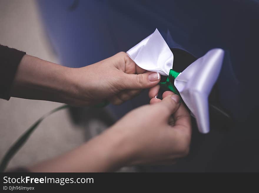 Woman tying a white bow