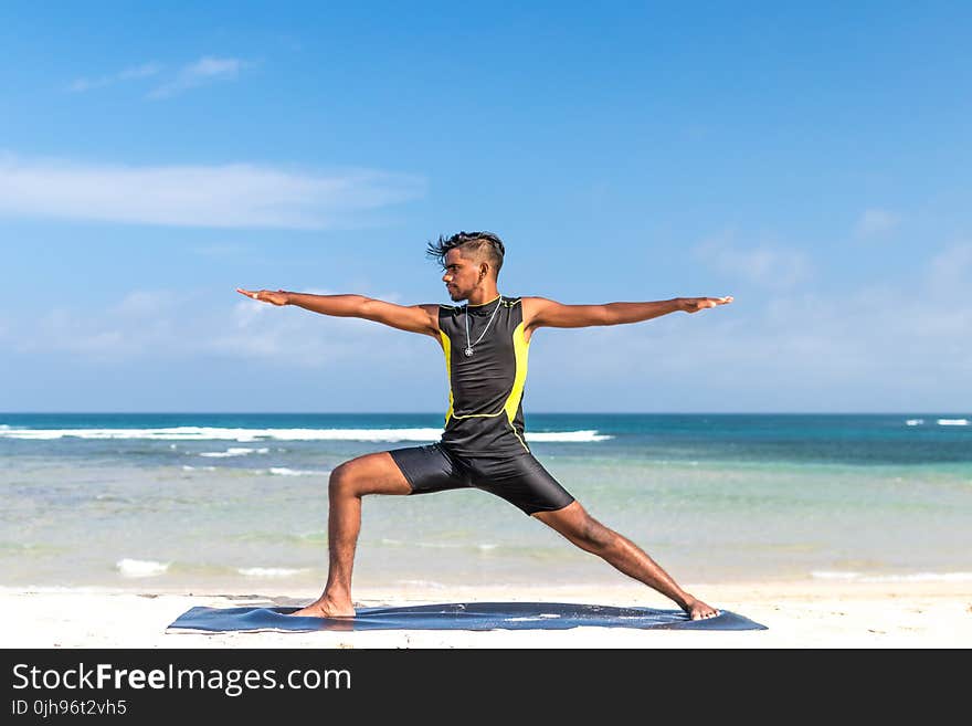 Man in Sleeveless Wet Suit Doing Some Aerobics at the Beach