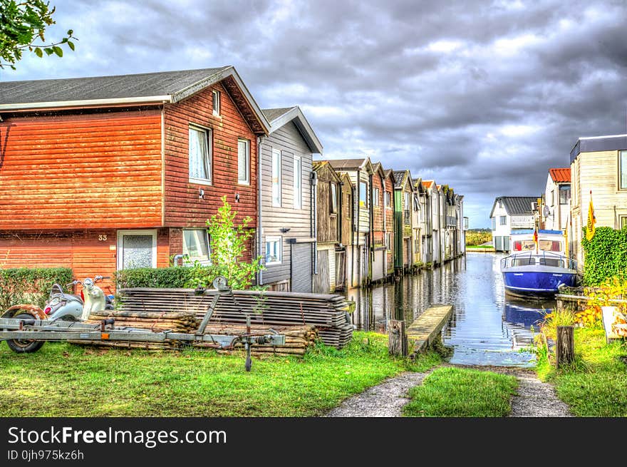 Photo of White and Blue Speedboat Beside Houses