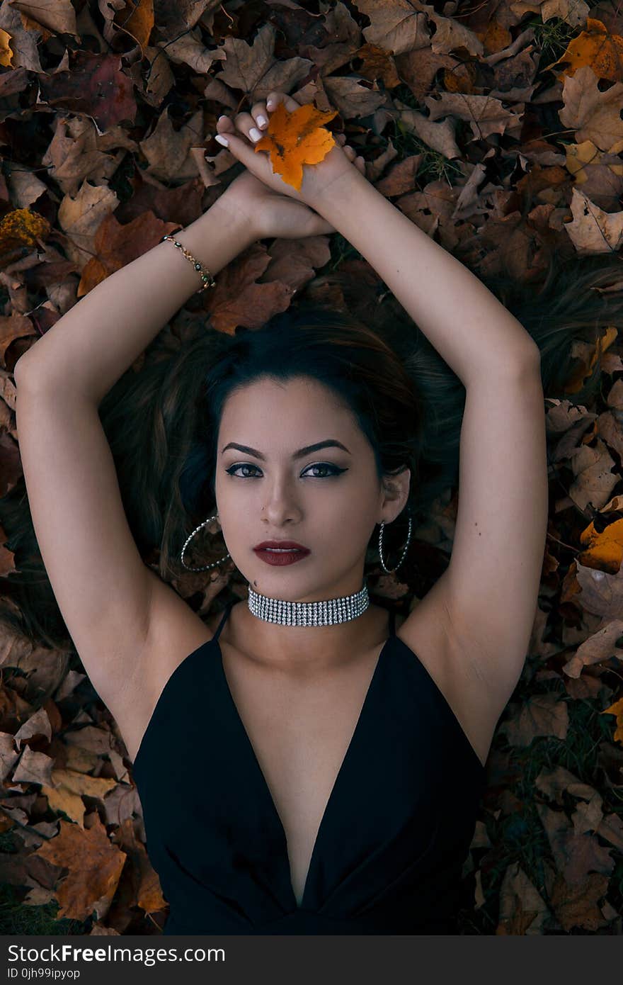 Woman Lying Opening Arms Holding Leaf