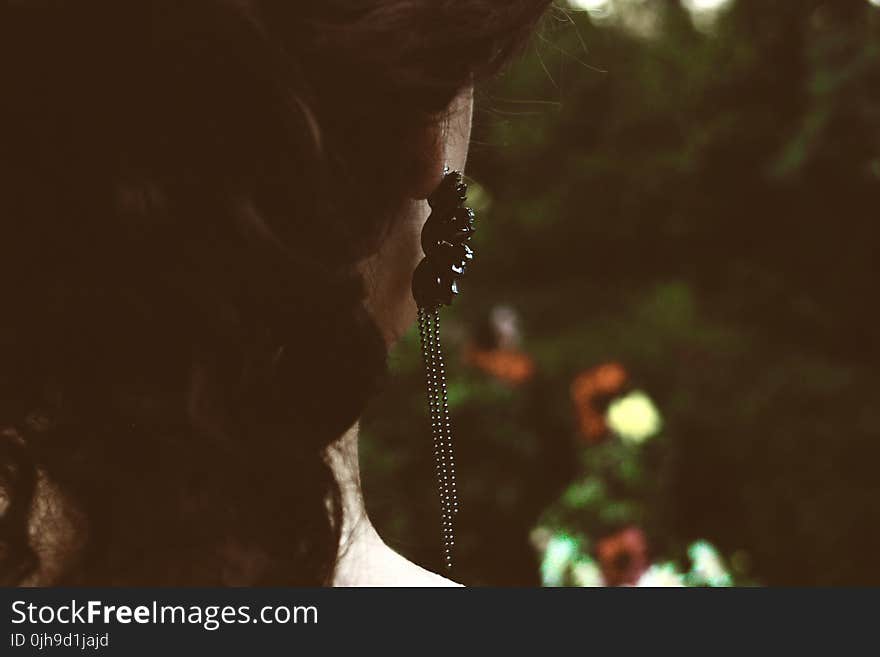 Selective Focus Photography of Woman&#x27;s Back With Black Pendant Earrings