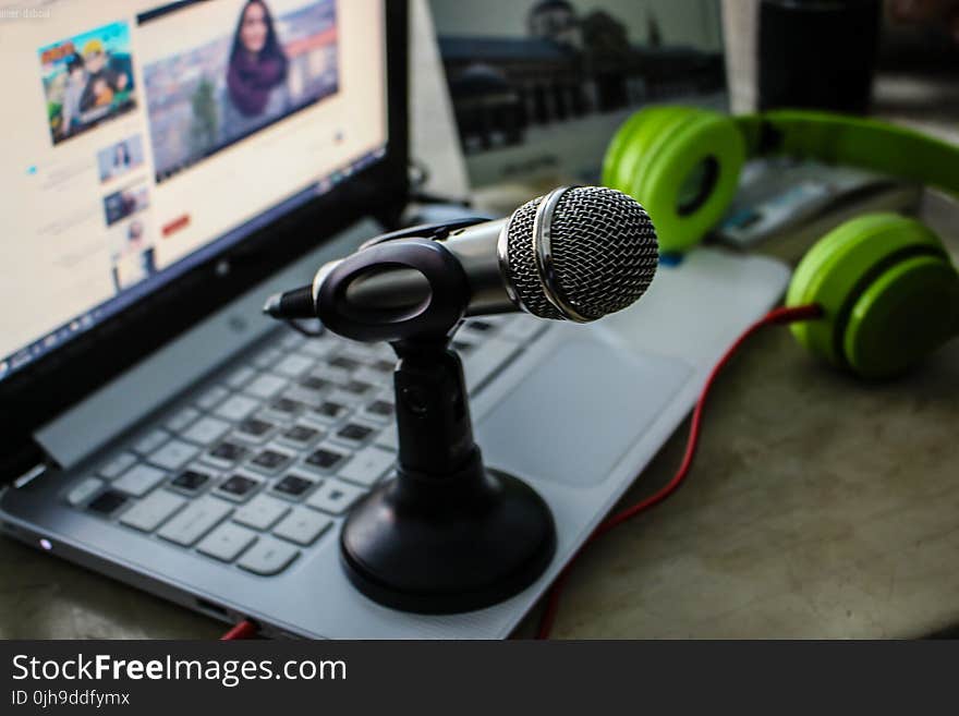 Green Headphones Near Laptop and Microphone