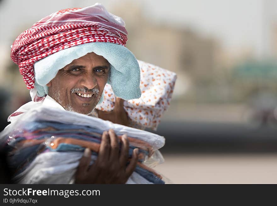 Man Holding Clothing While Smiling