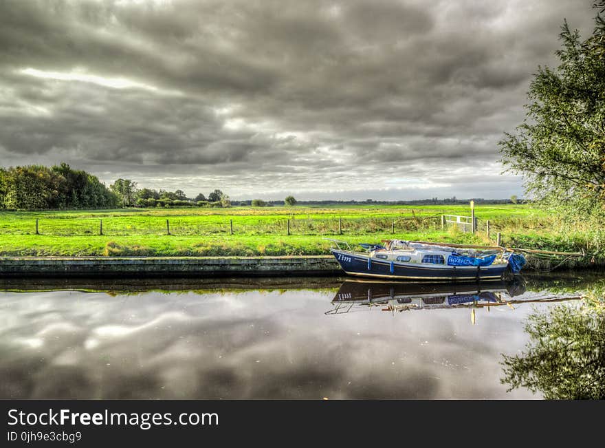 White and Blue Power Boat on Body of Water Under Clouds