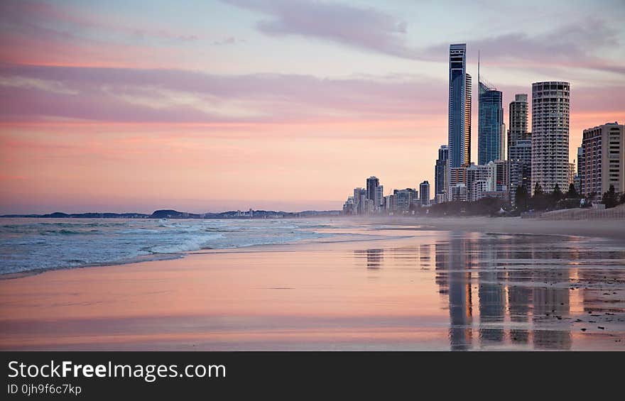 Tall City Buildings Near Beach Shore during Sunset