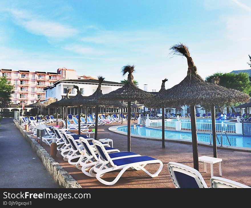 White Plastic Beach Loungers Near Pool at Daytime