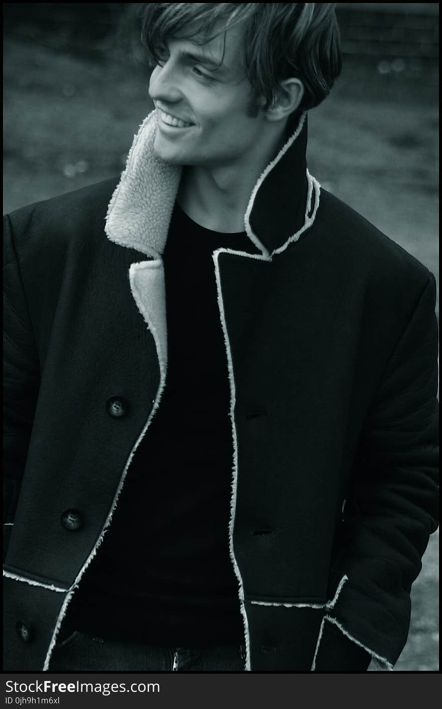 Grayscale Photo Of Man Wearing Black Button-up Notch Lapel Coat Smiling