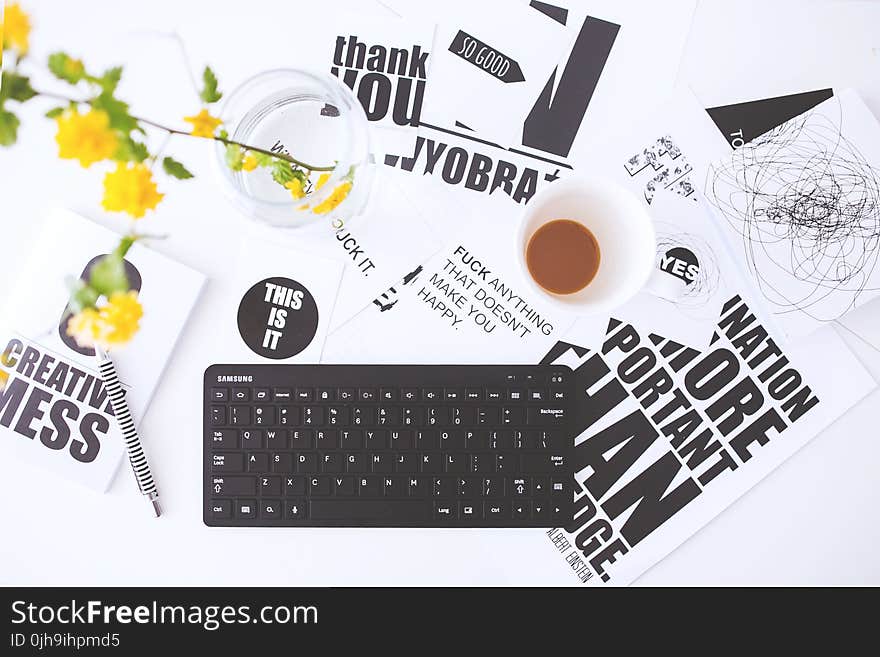 Top view of creative workspace with keyboard and coffee