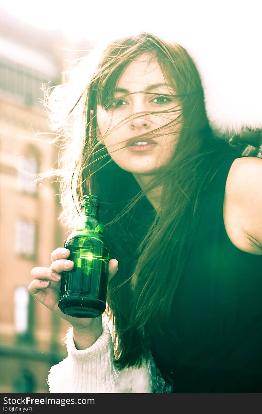 Woman In Black Sleeveless Shirt Holding A Bottle