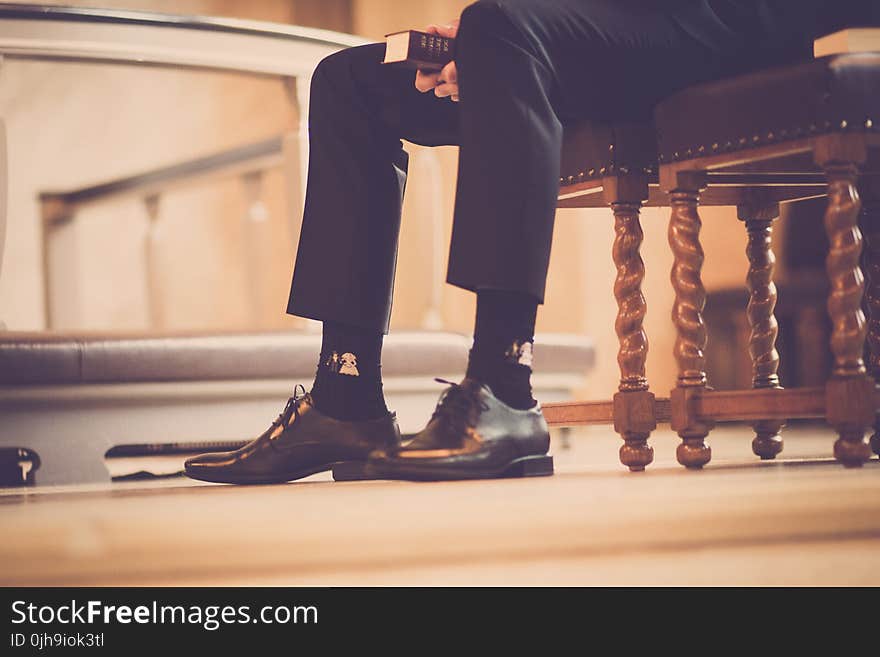 Person Sitting On A Chair Holding Book