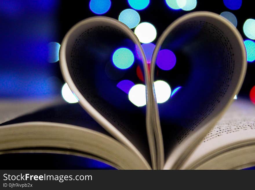 Photo of Bookpages Folded Into Heart Shape With Bokeh Light Background