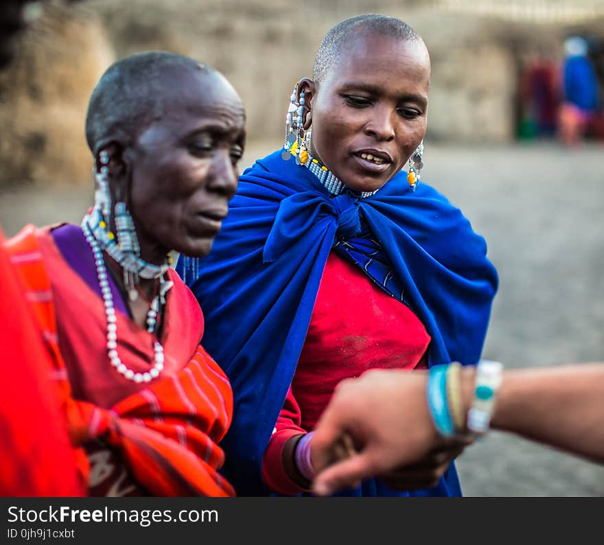 Two Woman Looking on Persons Bracelet