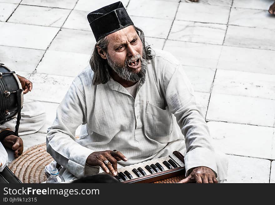 Man Sitting Holding Instrument