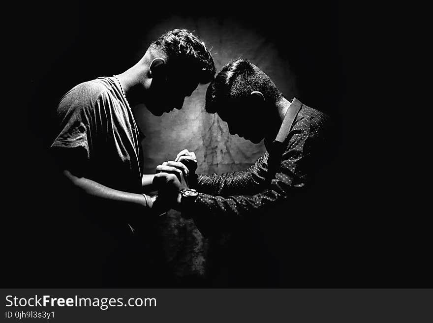 Grayscale Photo of Two Men Holding Hands