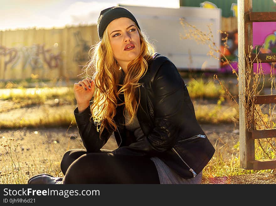 Woman Sitting Near Brown Wooden Plank