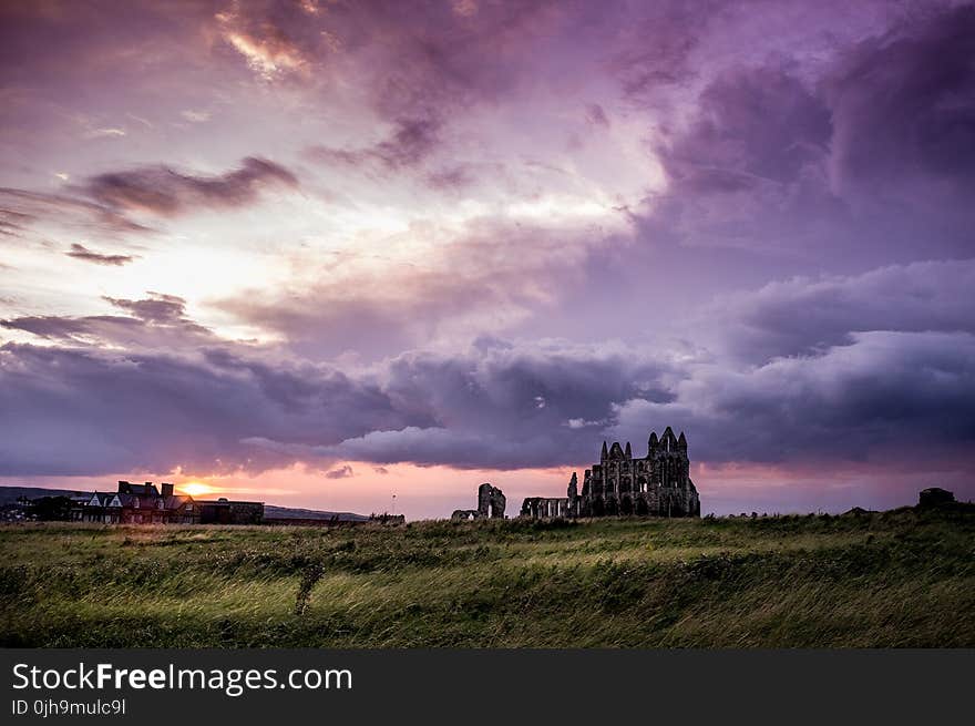 Green Field and White and Black Concrete Structure during Sunset