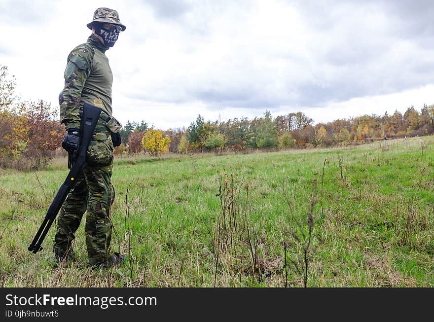 Photo of Man Wearing Green Combat Uniform Holding Rifle