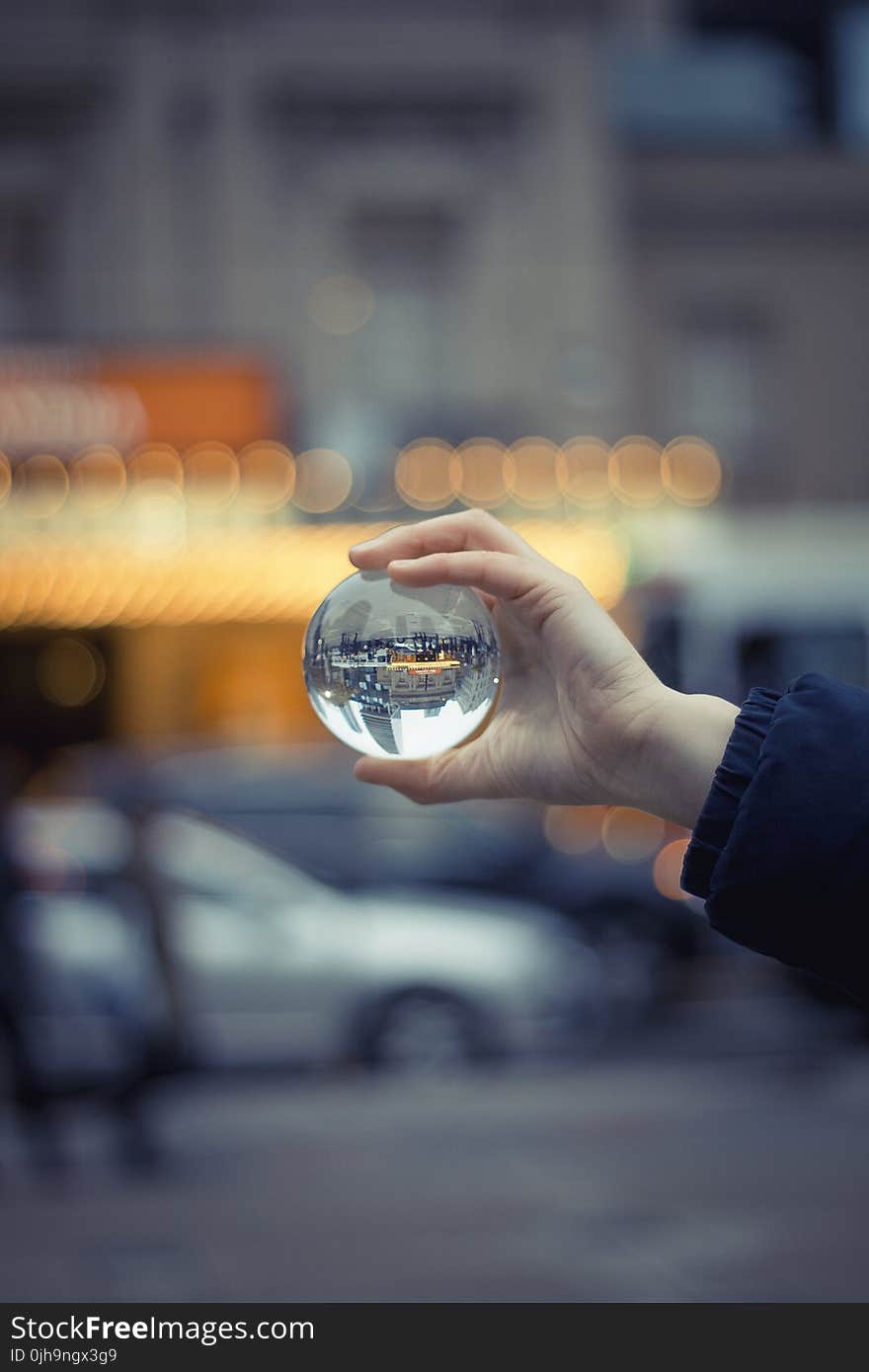 Person Holding Round Glass Ball Macro Shot