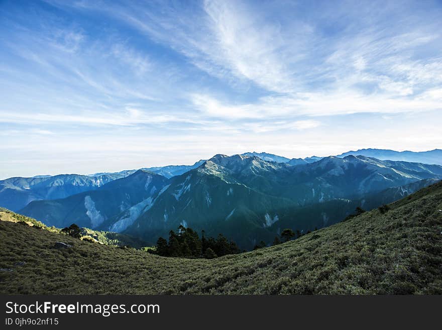 Landscape Photograph of Mountains Under Blue Cloudy Sky