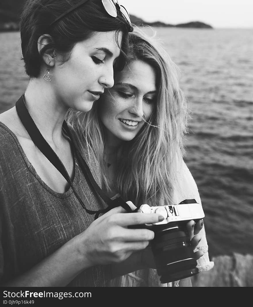 Grayscale Photo Of Two Women Looking At A Camera