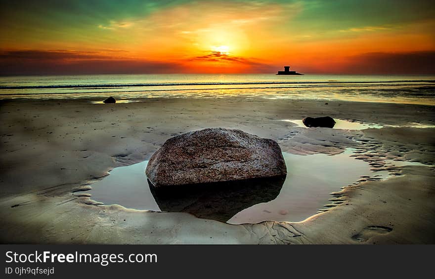 Stone Beside Seashore at Sunset