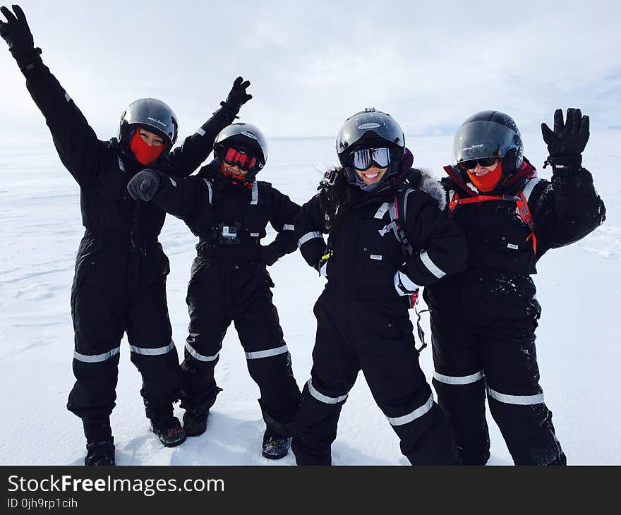 Four Person Wearing Black Snow Suit