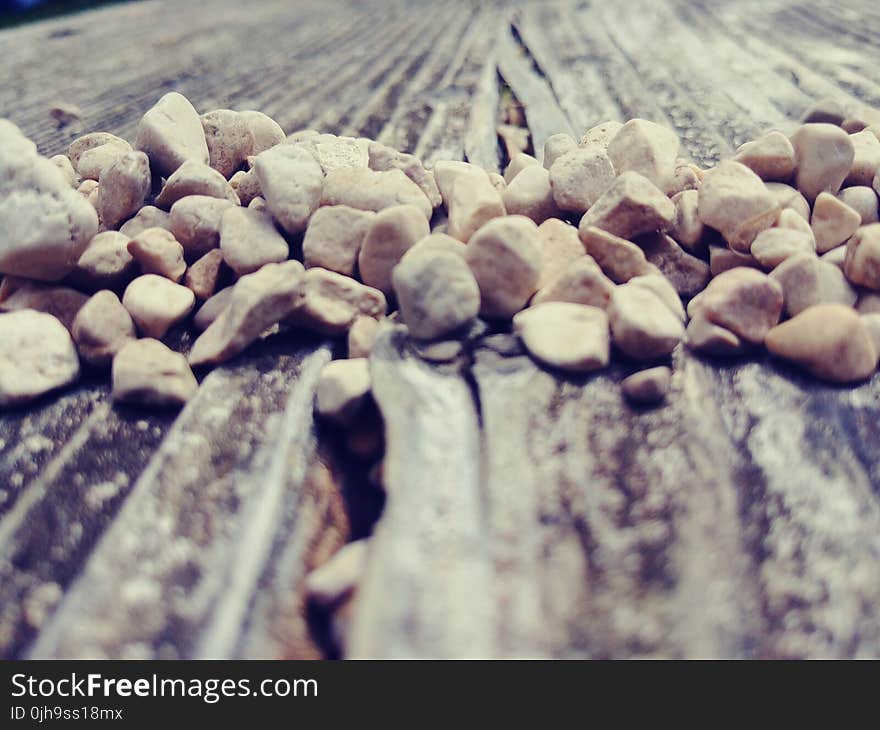 Pile of Beige Stone on Brown Wood Surface