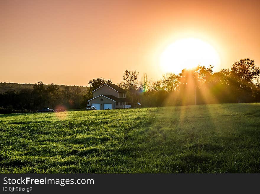 Green Field and Brown and White House during Sunrise