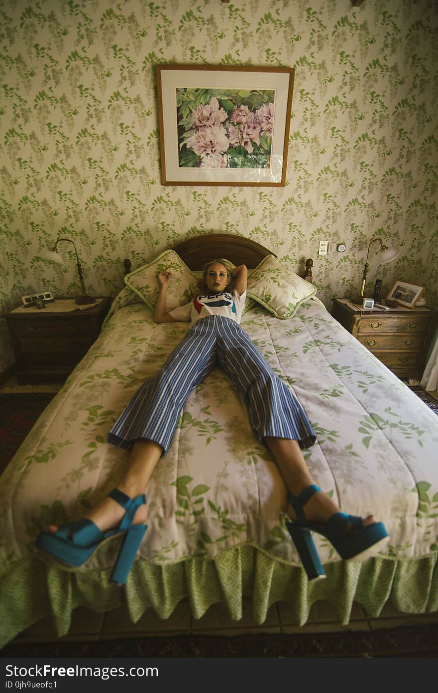 Woman in White Shirt Lying on White and Green Bed