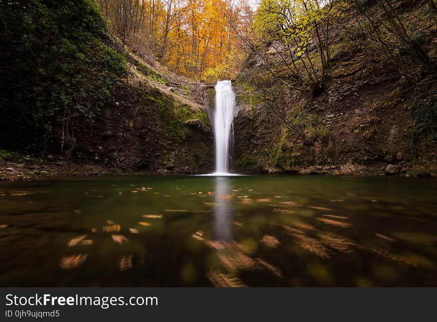 Low Angle Photo of Waterfalls Surrounded by Trees