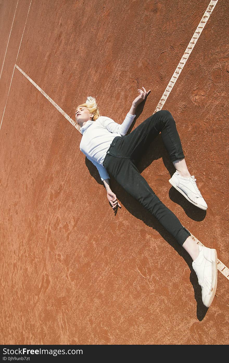 Woman Lying Down on a Brown Concrete Surface