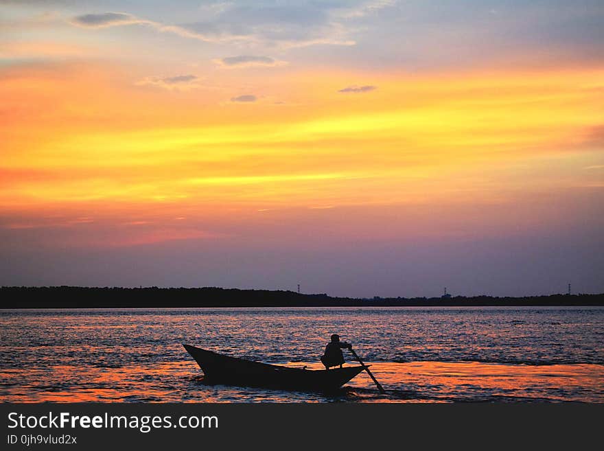 Silhouette Of Man On Boat In Water