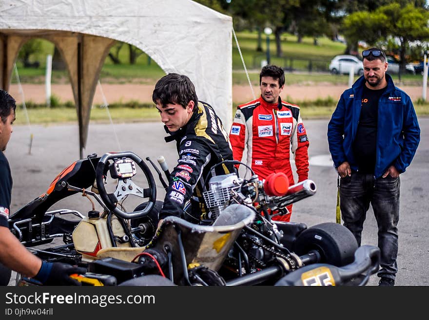 Two Motorcycle Racers Standing in Front of Motorcycles