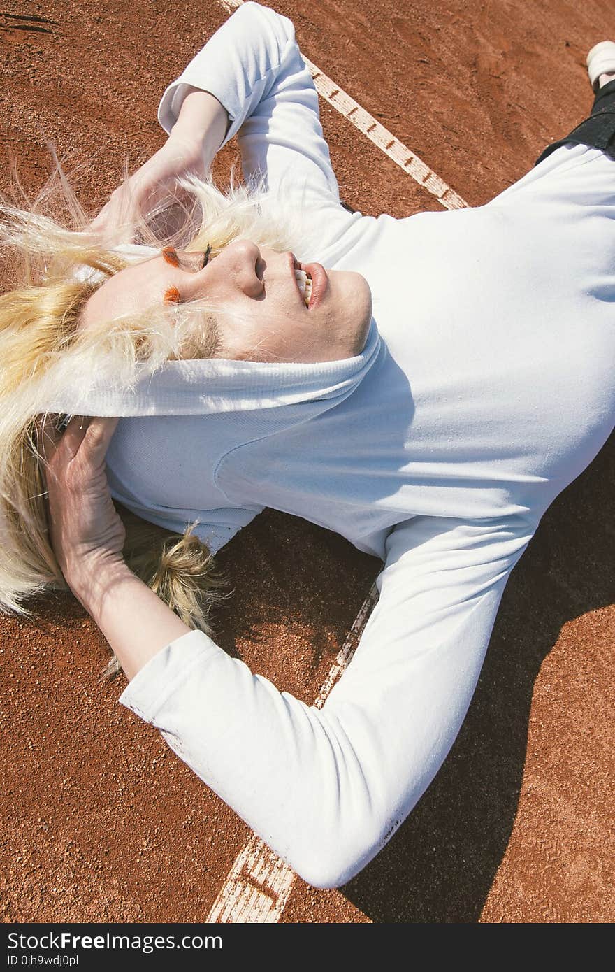 Woman Wearing Pull over Hoodie Laying on Brown Carpeted Floor