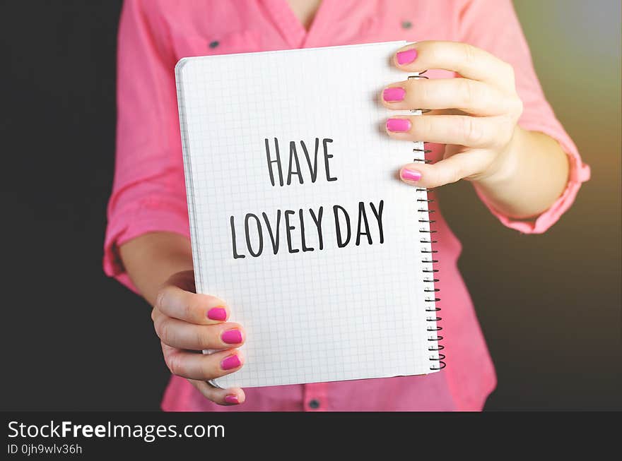 Woman Wearing Pink Dress Holding Graphing Notebook With Have a Lovely Day Sign