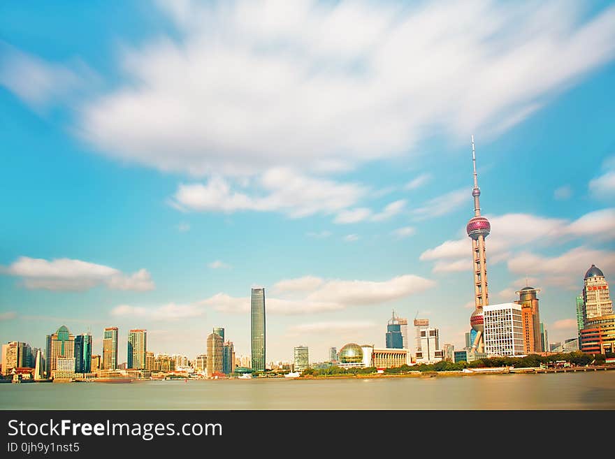 Pearl Tower Near Body of Water Under Clouds Photo Taken