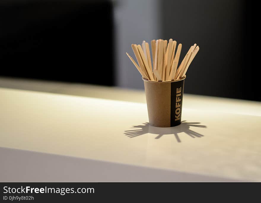 Brown Popsicle Sticks in Brown Disposable Cup