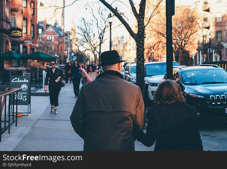 Man in Black Hat Holding His Wife