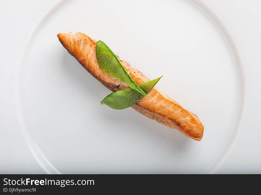 Cooked Fish With Two Green Leaf on Round White Ceramic Plate