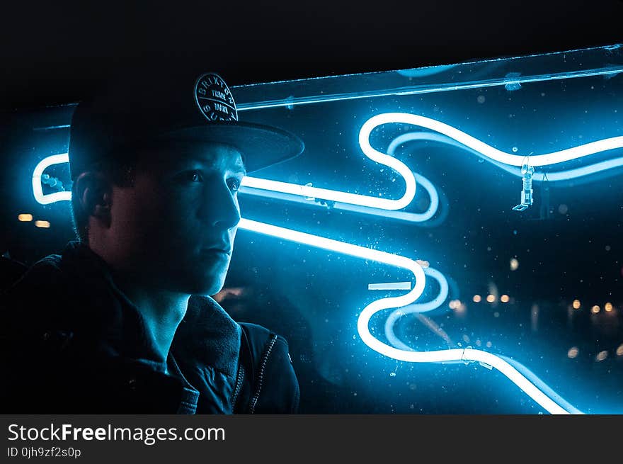 Man In Black Jacket Beside Blue Neon Light Guitar