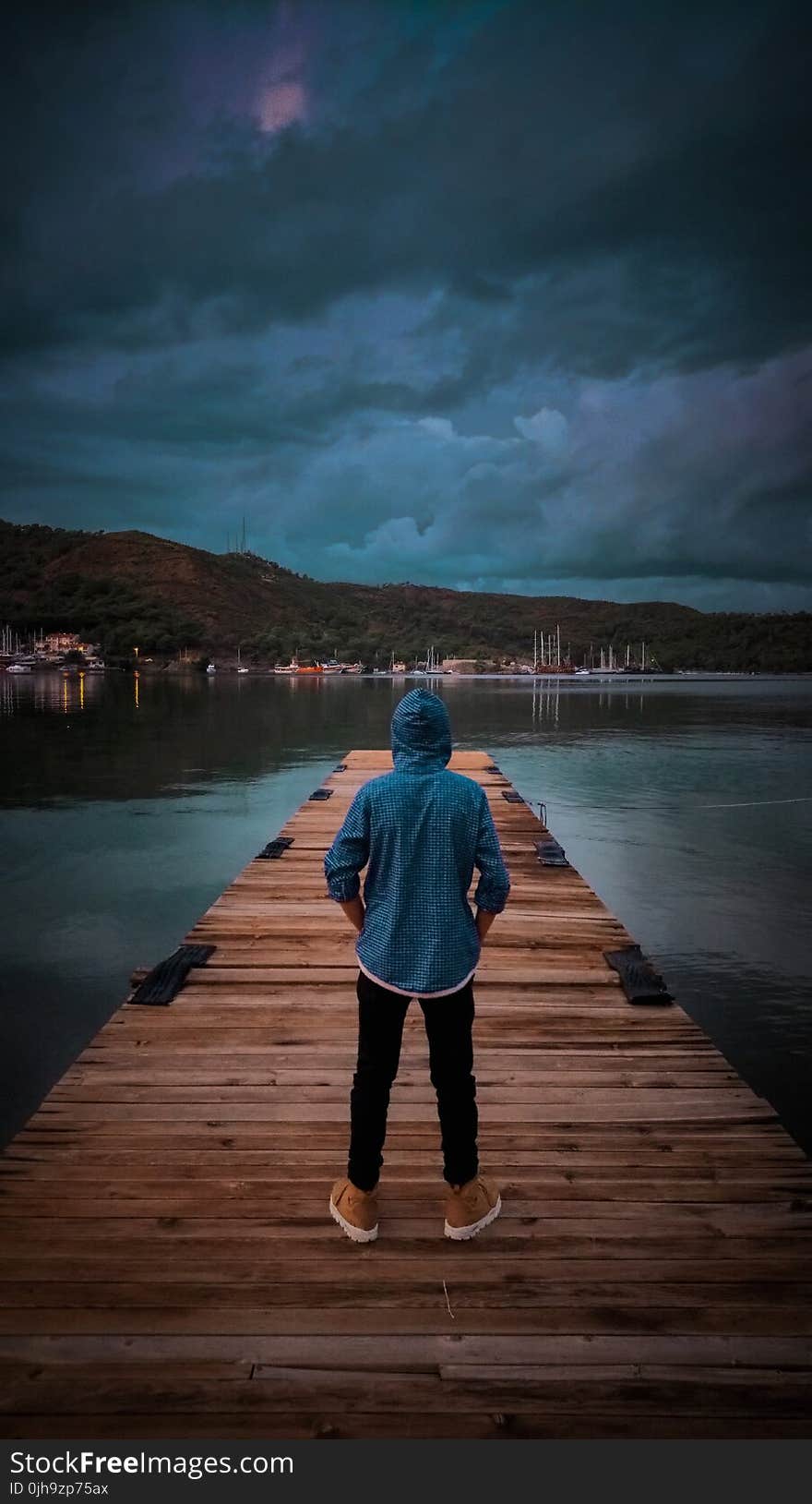 Man Wearing Blue Hoodie Standing On Wooden Dock