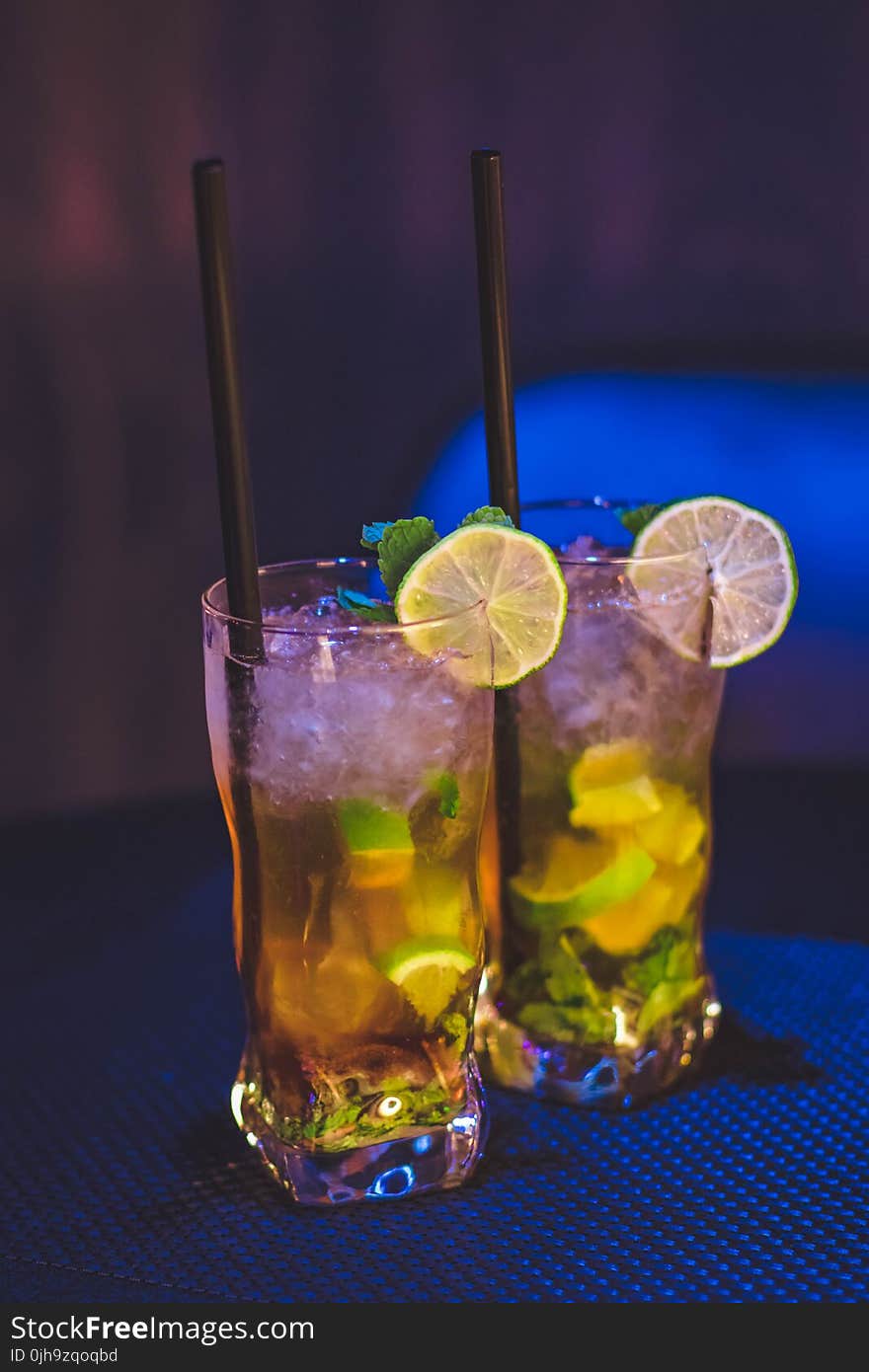 Two Clear Drinking Glass With Juice and Black Straw