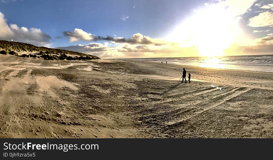 Photo of People Walking on Brown Sand