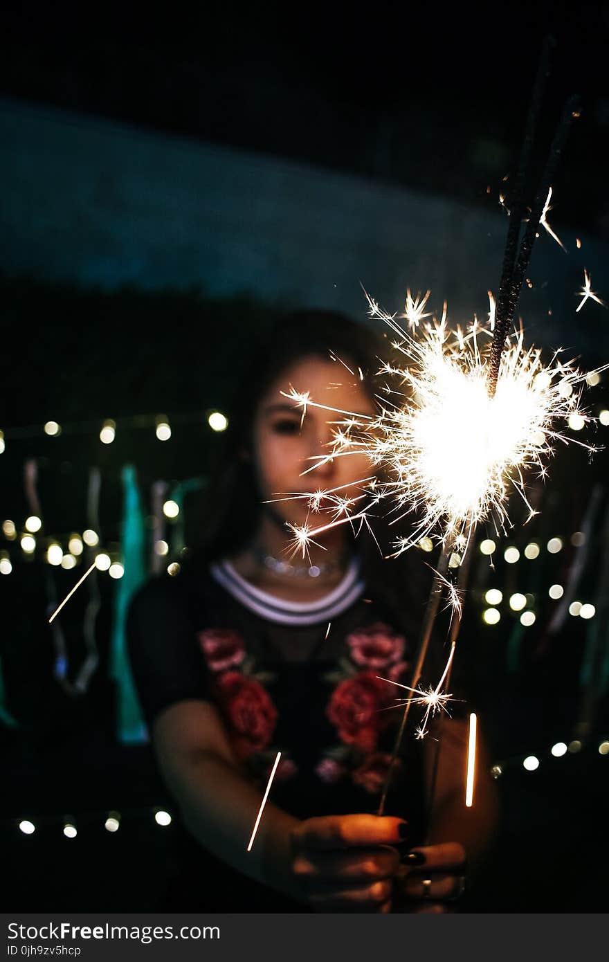 Woman Holding Sparkle during Nighttime