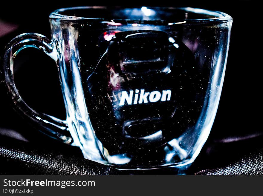 Close Up Photo Of Clear Glass Mug With Nikon Lens Cap