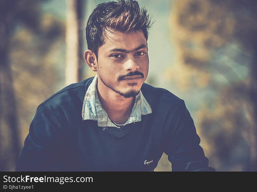 Shallow Focus Photography of Man Wearing Blue Sweater