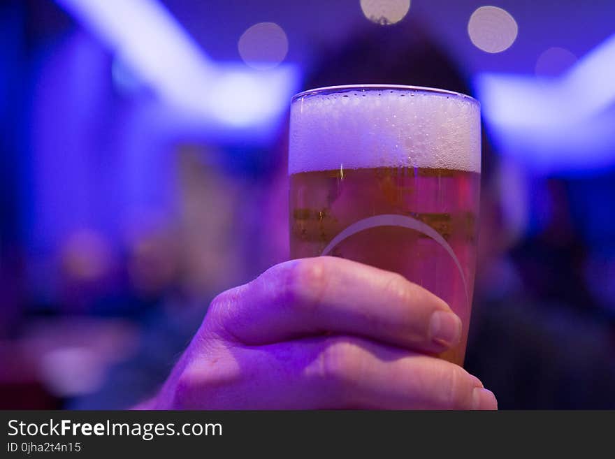 Person Holding Shot Glass Filled With Beer