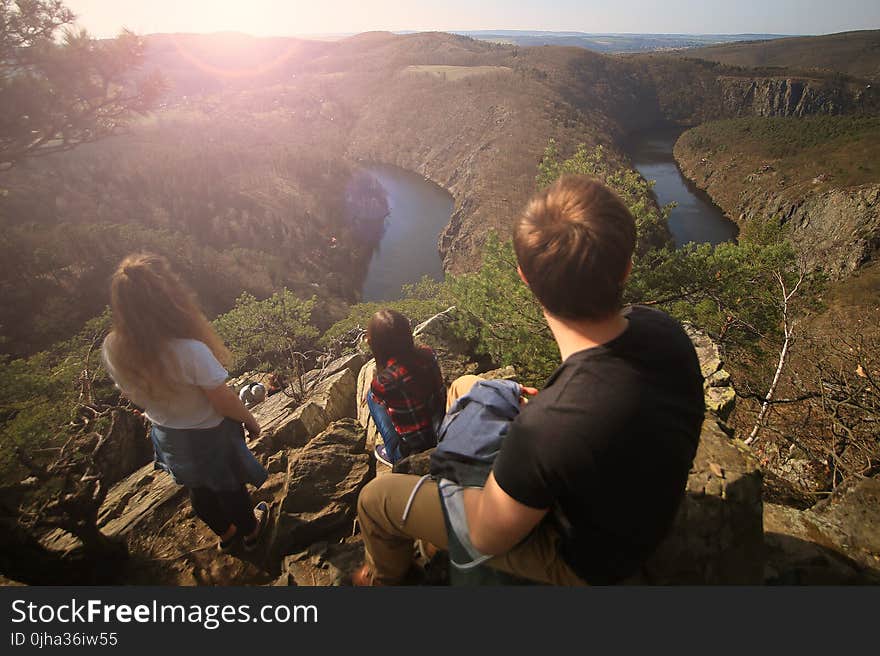 People on Top of Cliff With Water at the Bottom during Daytime