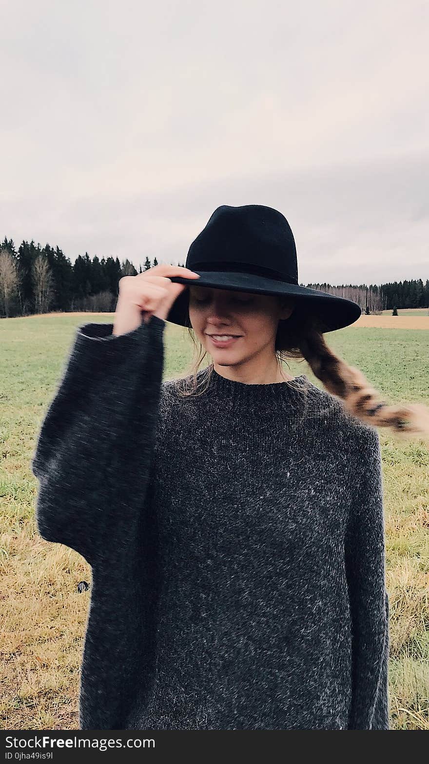 Woman Wearing and Holding Black Summer Hat Outdoor